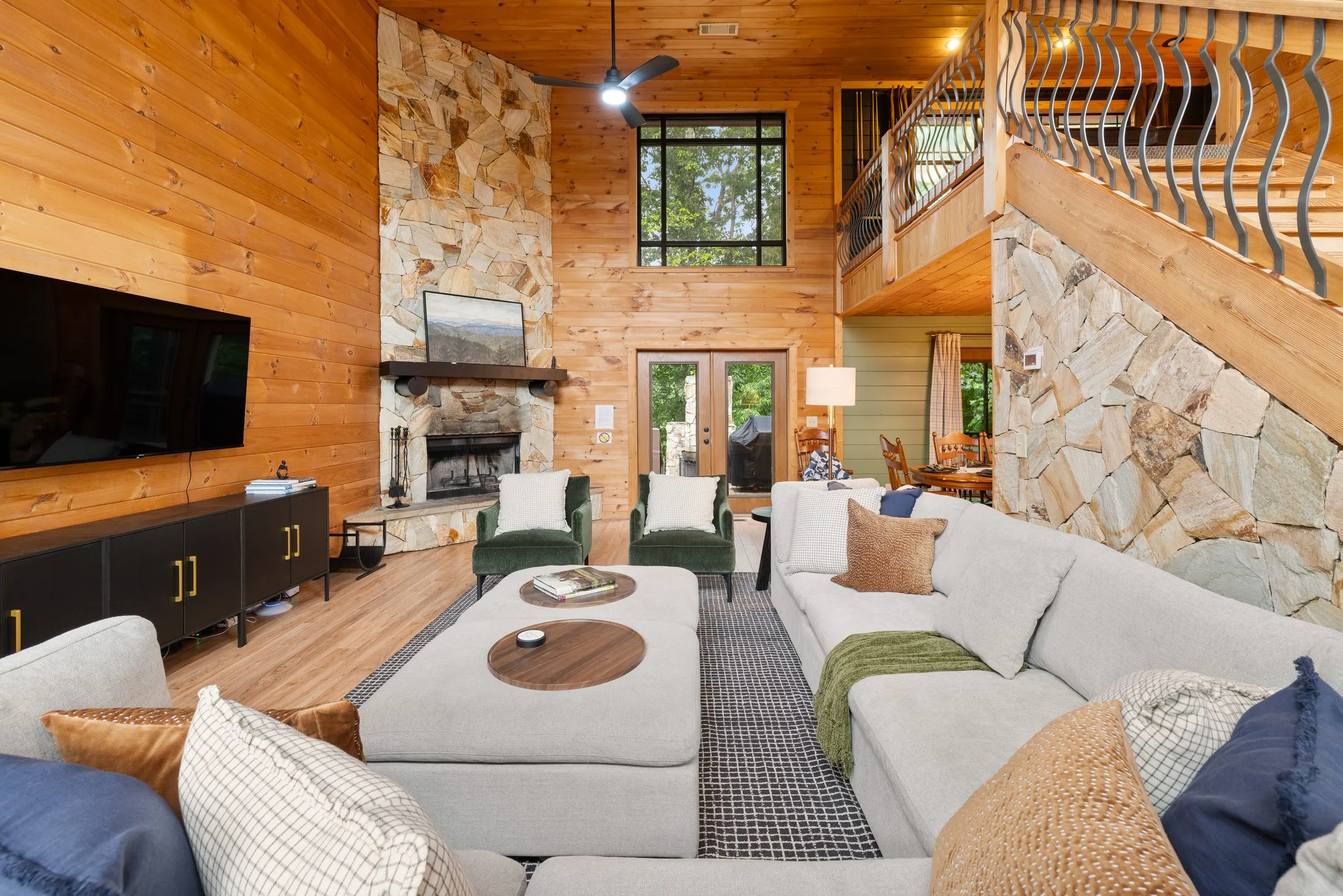 Two-story living room with stone fireplace, large sectional and loft